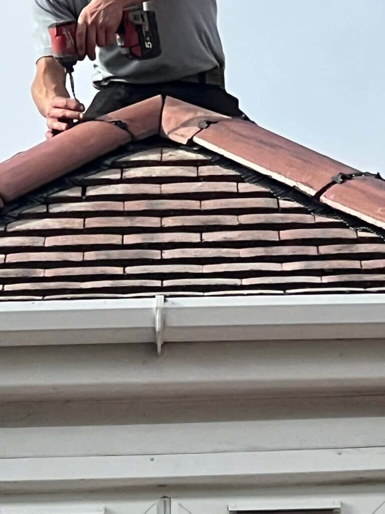 This is a photo of one of the operatives of LS Roofing Henley-on-Thames installing new ridge tiles