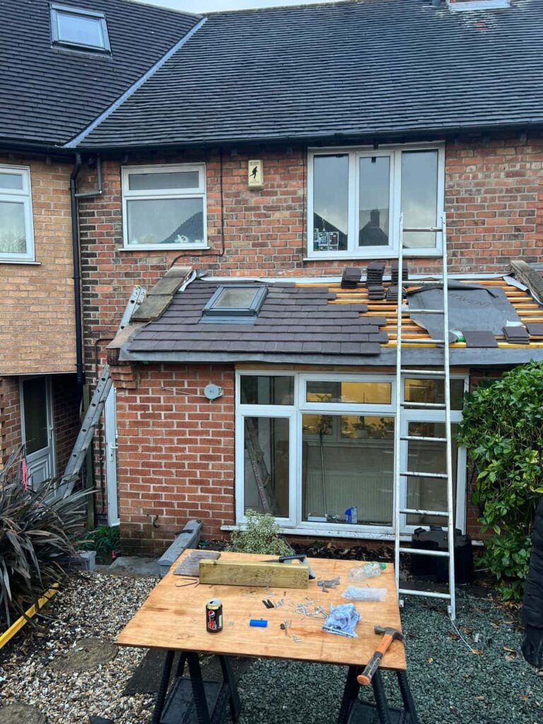 This is a photo of a roof extension that is having new roof tiles installed. This is a photo taken from the roof ridge looking down a tiled pitched roof on to a flat roof. Works carried out by LS Roofing Henley-on-Thames