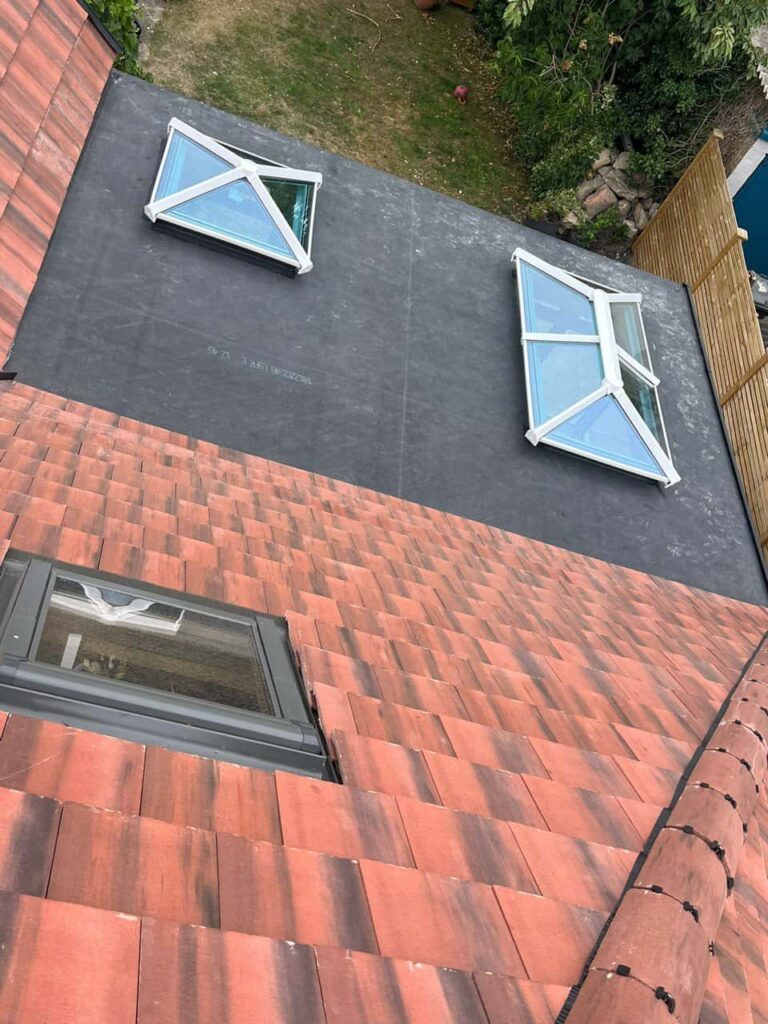 This is a photo taken from the roof ridge looking down a tiled pitched roof on to a flat roof. Works carried out by LS Roofing Henley-on-Thames